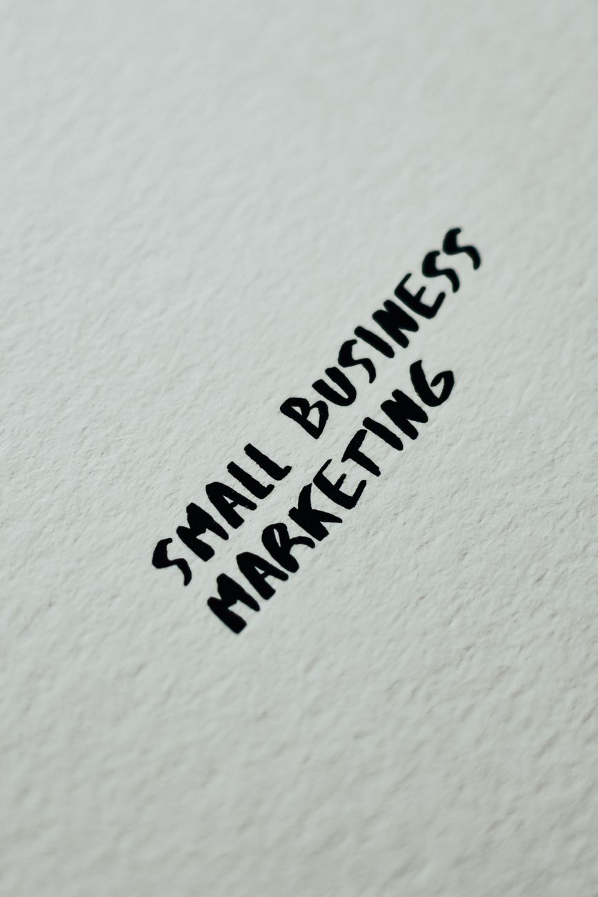 Close-up of small business marketing text handwritten on a white textured background for entrepreneurial themes.