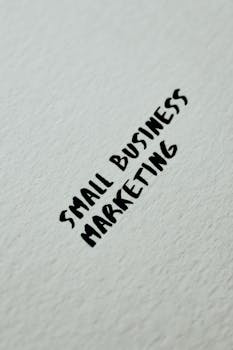 Close-up of small business marketing text handwritten on a white textured background for entrepreneurial themes.