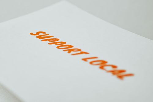 Free Close-up of a 'Support Local' slogan on a paper, promoting community-driven initiatives. Stock Photo
