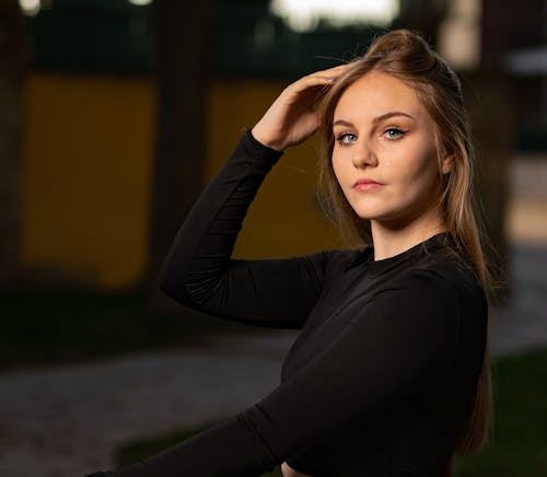 Woman in Black Long Sleeve Shirt Fixing Her Hair