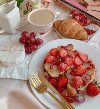 A delicious breakfast setup featuring croissants, fruits, and coffee for an inviting meal.