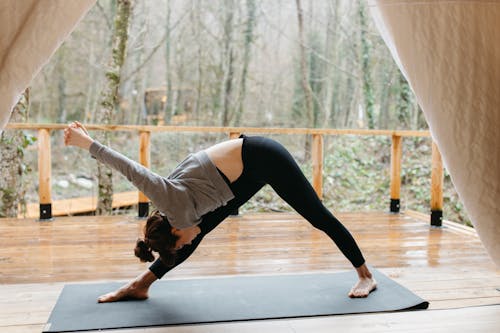 Woman in Gray Long Sleeve Shirt and Black Leggings Doing Yoga