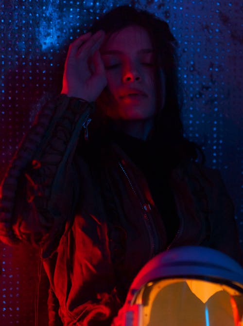 Woman in Spacesuit Sitting On Floor Looking Tired