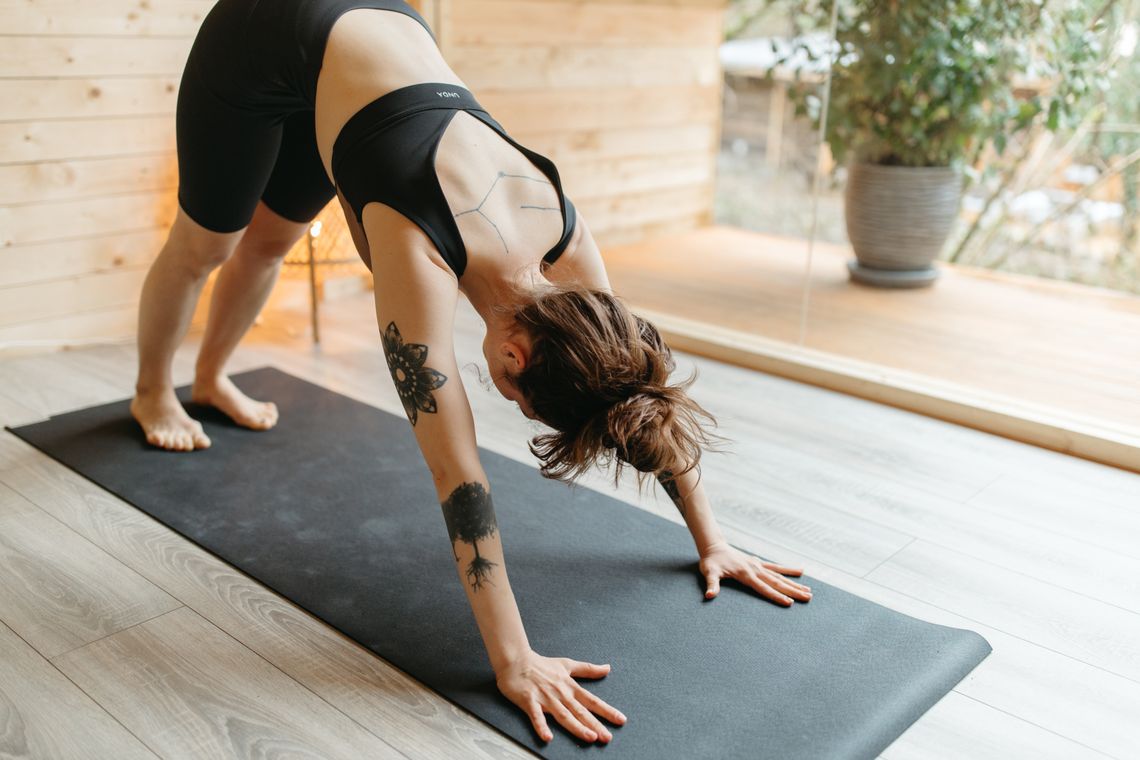 Woman in activewear practicing yoga in a modern studio