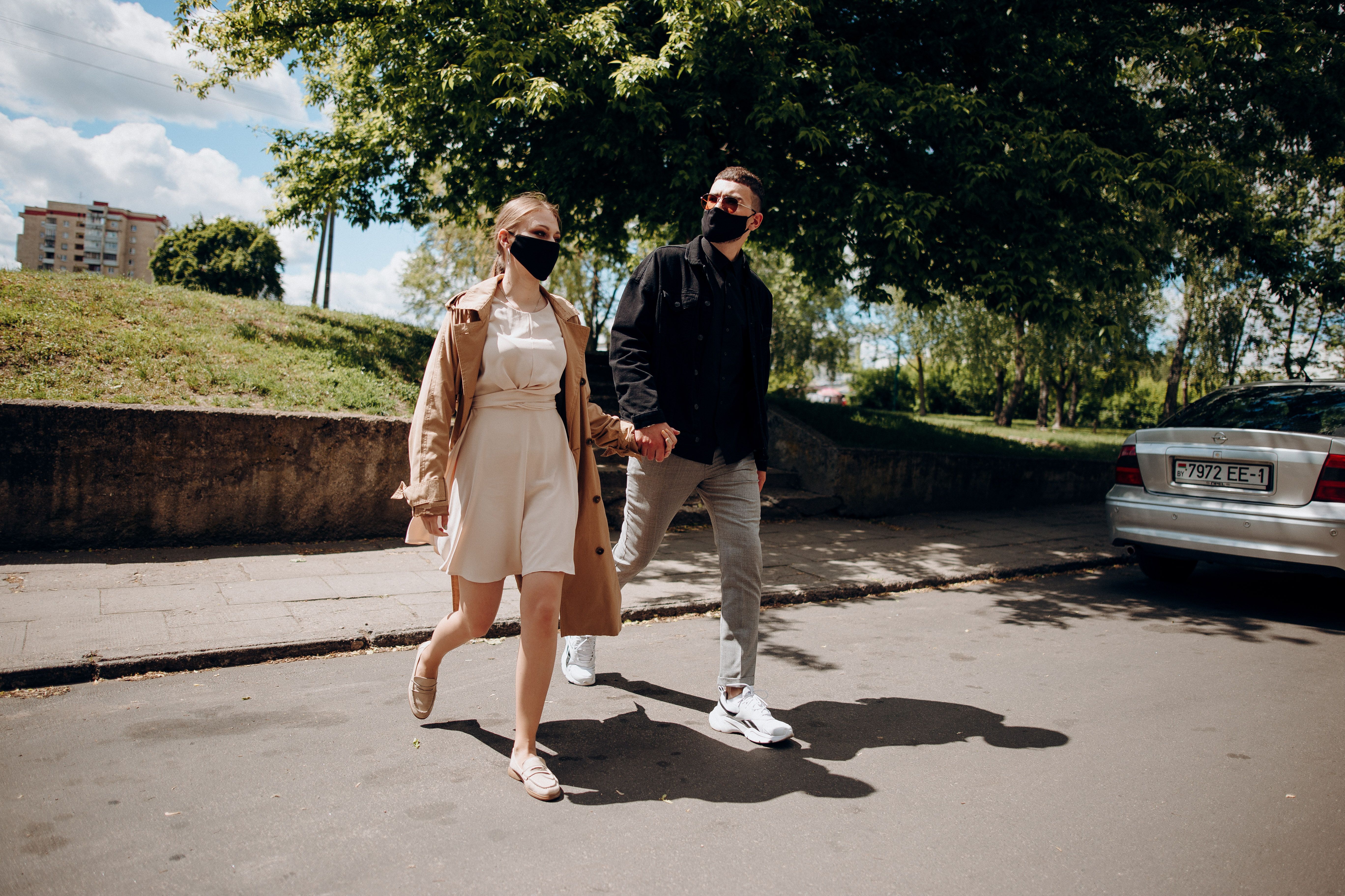 A Couple Holding Hands while Walking on the Street · Free Stock Photo