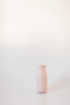 Stylish pink bottle against a white background, perfect for minimalistic themes.
