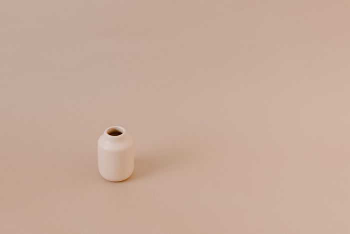 Minimalistyczny ceramiczny wazon na ciepłym, neutralnym tle