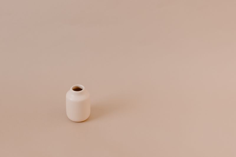 Minimalistyczny ceramiczny wazon na ciepłym, neutralnym tle