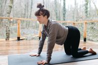 Woman in Gray Long Sleeve Shirt and Black Pants Doing Yoga Pose
