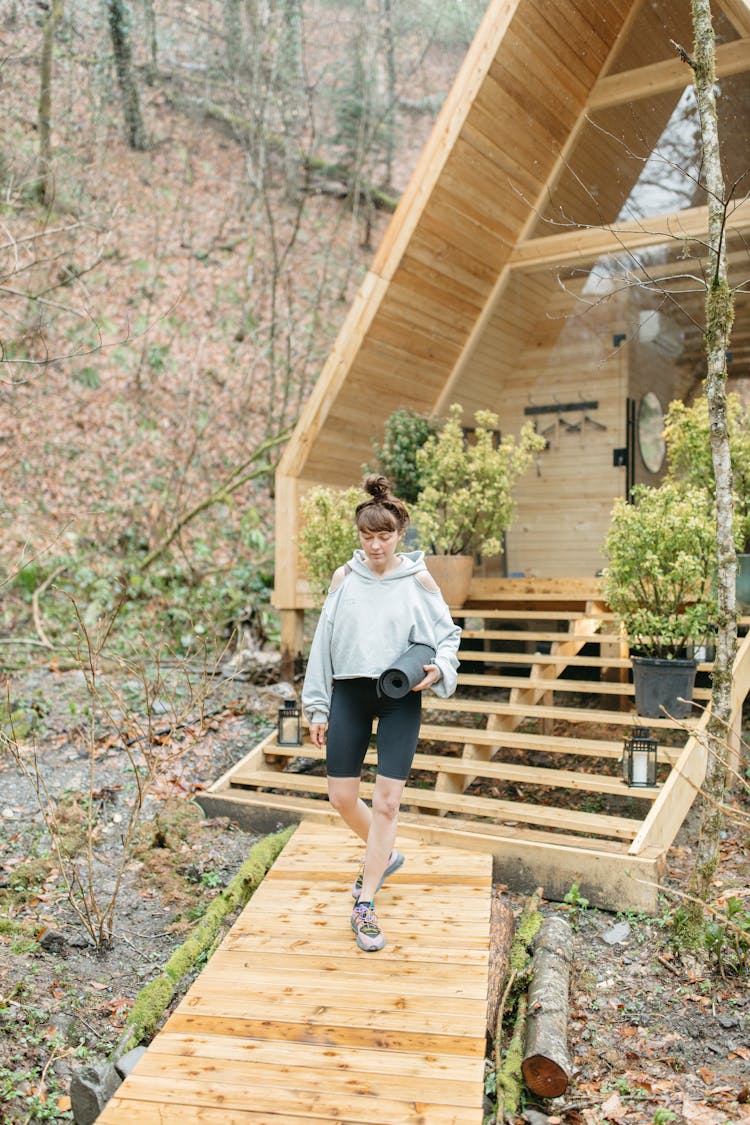 Woman In Gray Sweater Walking On A Boardwalk