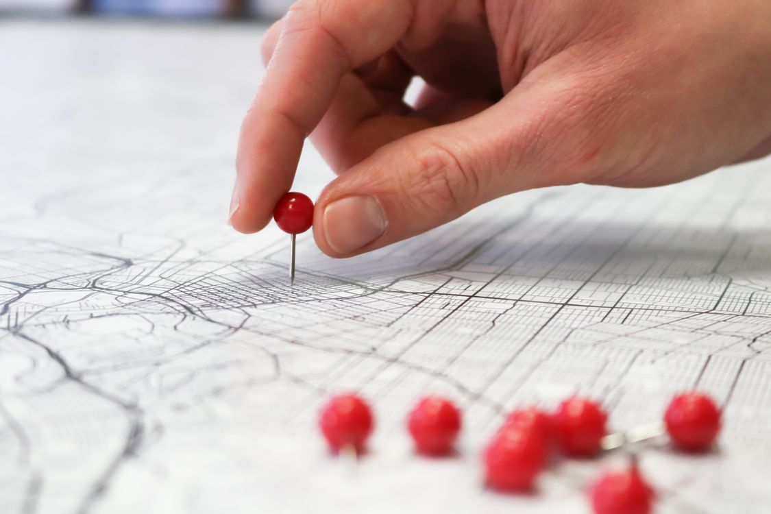 hand placing pin on map local business