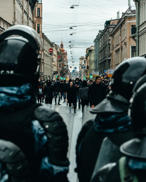 Free A tense city street scene featuring police officers and a crowd during a protest. Stock Photo