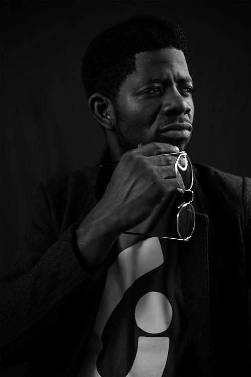Free Black and white portrait of a man with eyeglasses in hand, posing thoughtfully. Stock Photo