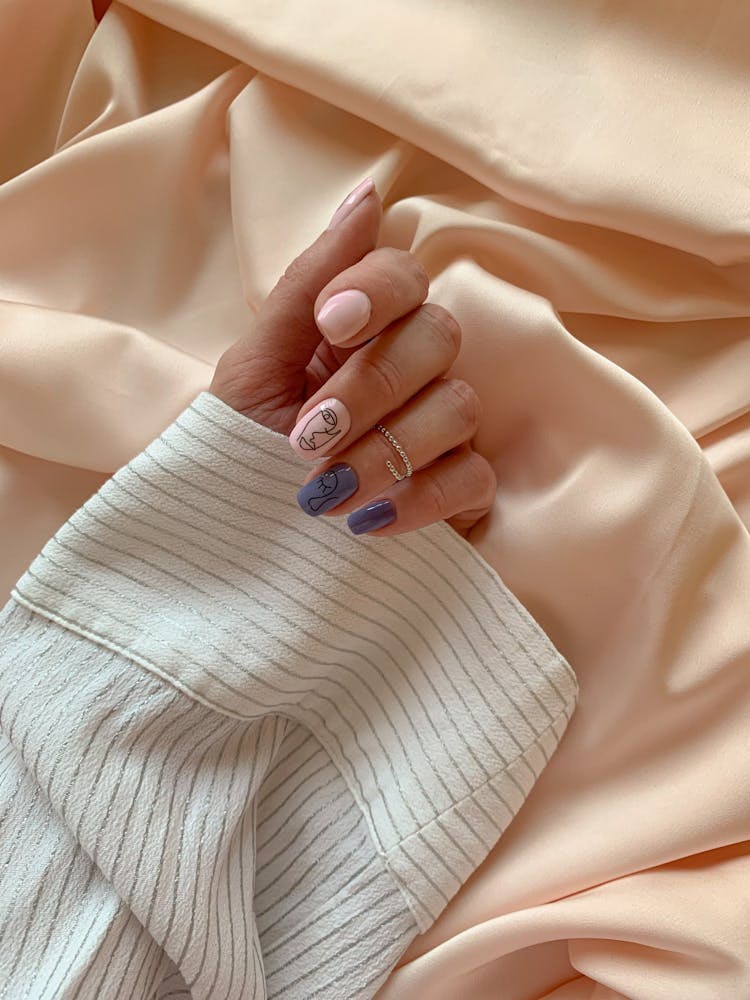 A Hand With Manicured Nails On White Textile