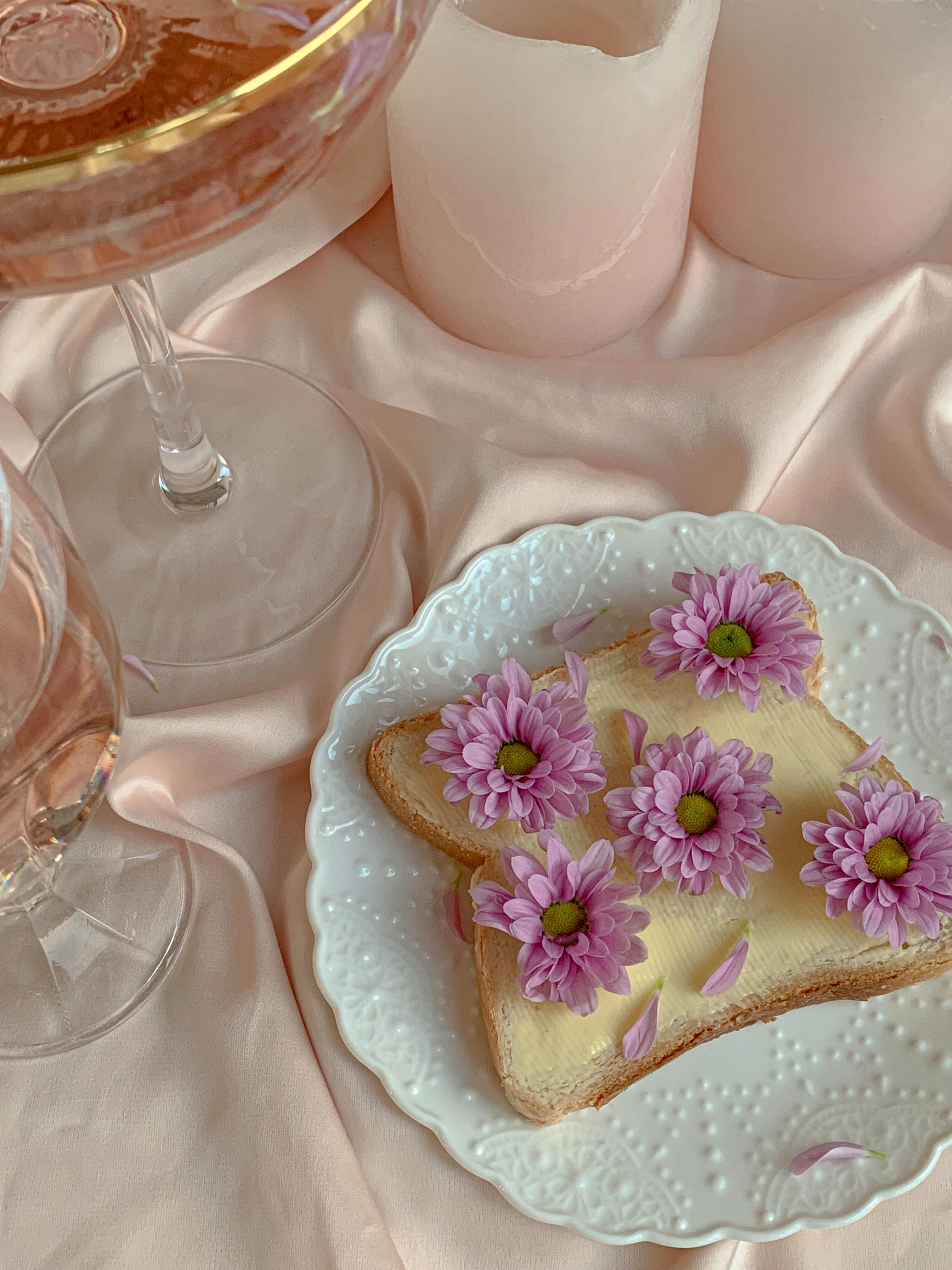Aesthetic display of toast adorned with pink flowers on pastel settings.