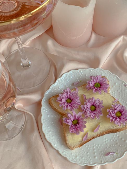Aesthetic display of toast adorned with pink flowers on pastel settings.