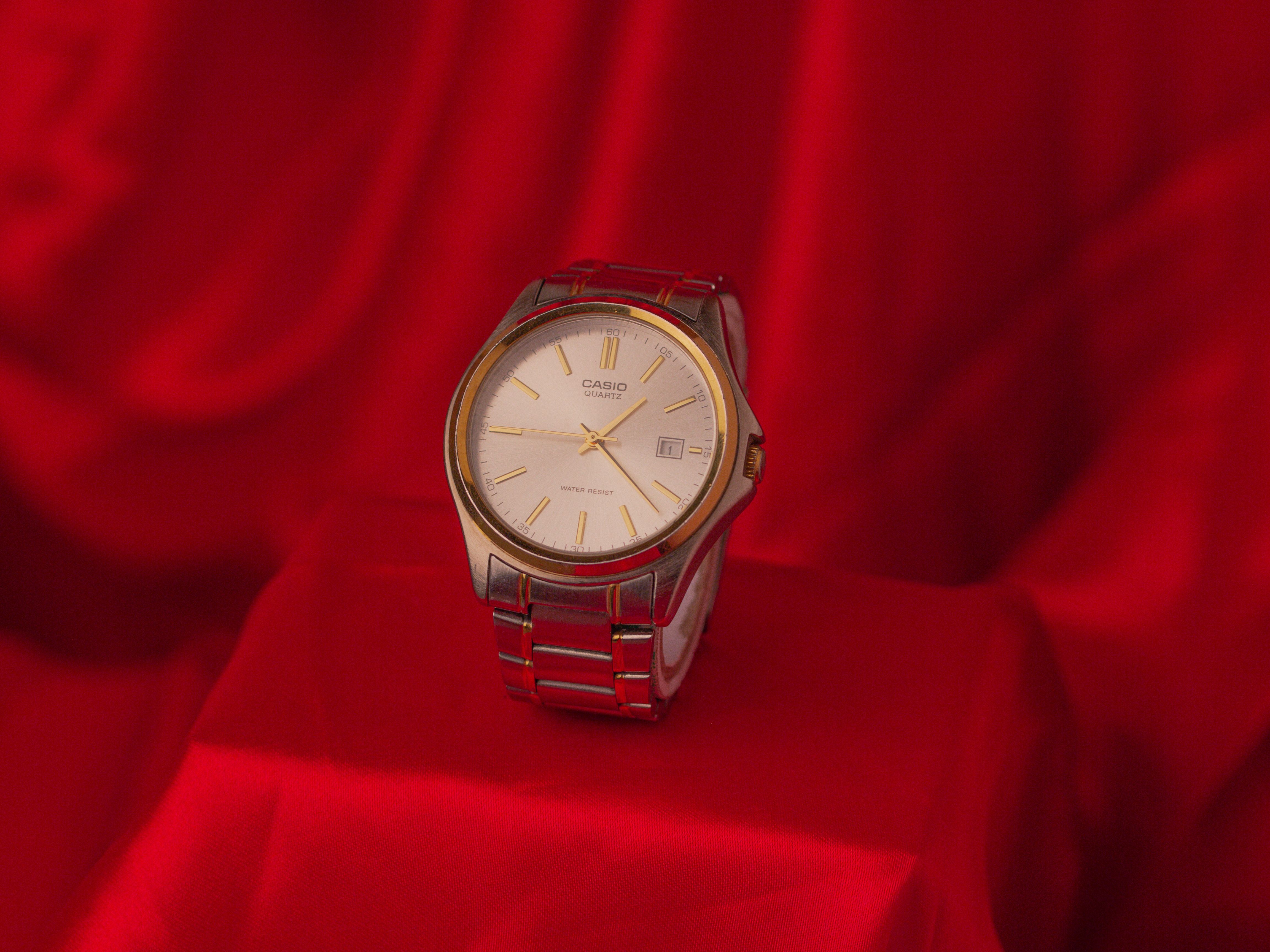 A Wilver and Gold Watch on the Red Fabric · Free Stock Photo
