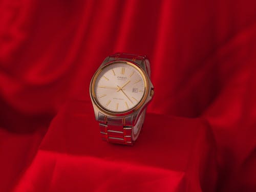 A Wilver and Gold Watch on the Red Fabric