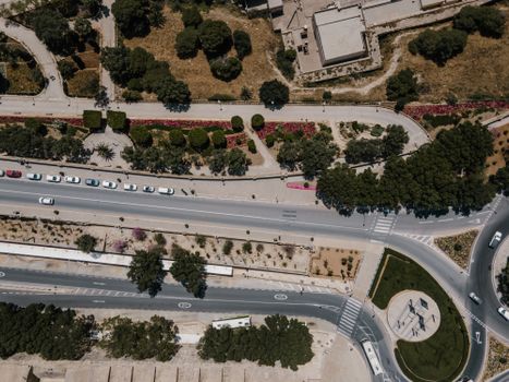Aerial shot of Valletta, Malta showcasing roadways and green landscapes from above.
