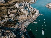 Stunning aerial view of Wied il-Għajn's marina and coastal buildings in Malta, capturing vibrant waterfront life.
