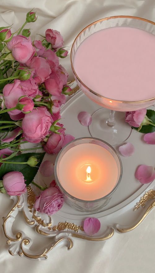 Free Photo of a Lit Candle Near Pink Roses Stock Photo