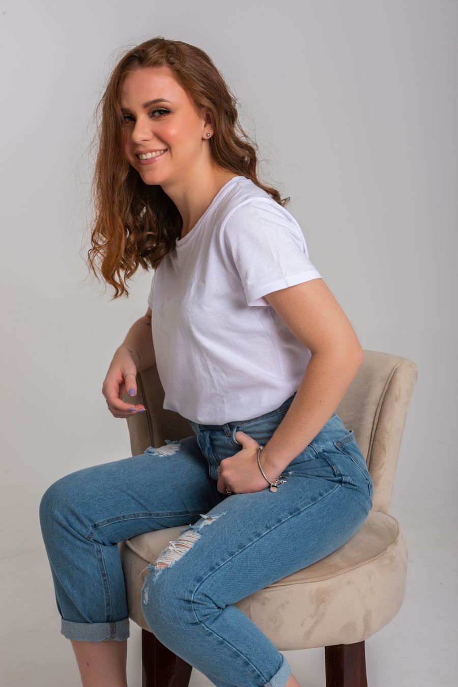 Woman in a white shirt and jeans in a studio