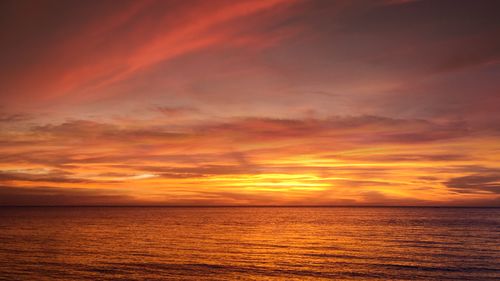 Free Breathtaking sunset over the serene ocean with vibrant colors filling the sky. Stock Photo