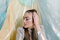 女人与长发和闪闪发光的妆容在一个银色的衣服在一个丰富多彩的抽象背景