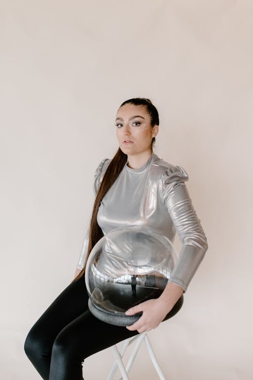 Free A Woman in a Gray Top Holding a Glass Helmet Stock Photo