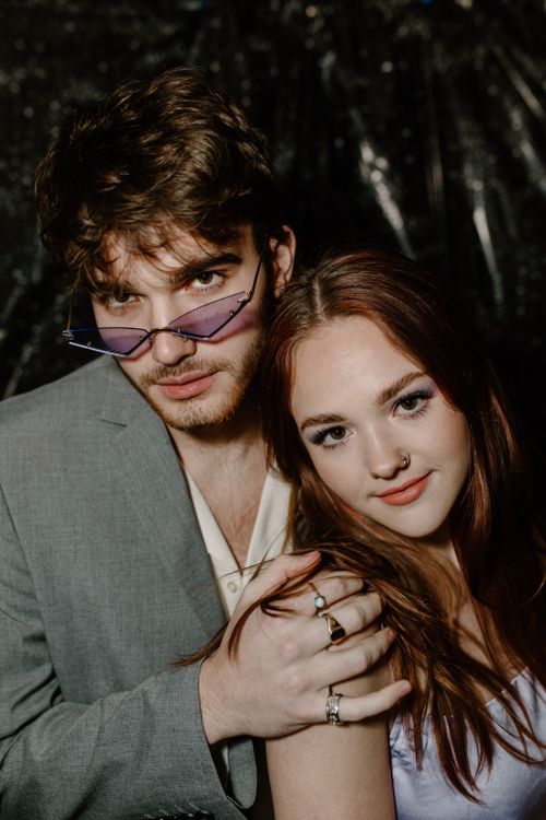 Free A fashionable young couple poses stylishly with an artistic backdrop, highlighting contemporary style. Stock Photo