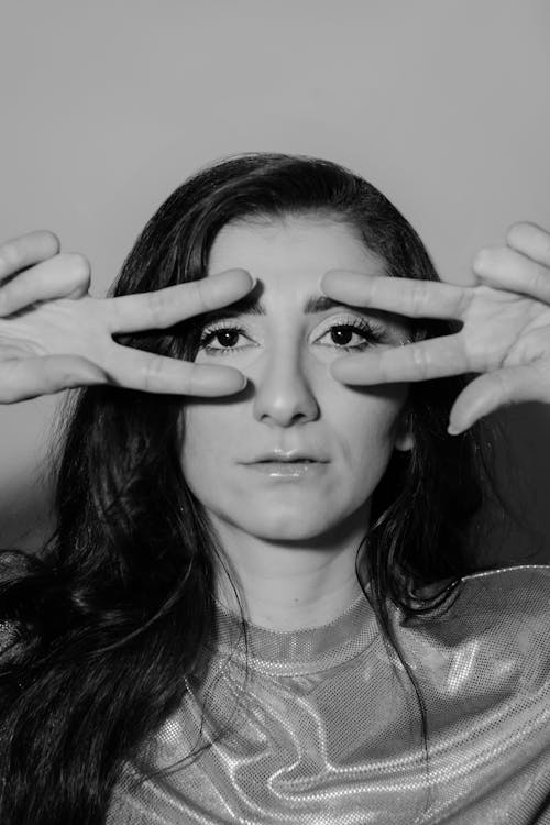 Grayscale Photo of a Woman with Her Fingers on Her Face