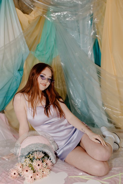 Woman in White Tank Top Sitting on Green Textile