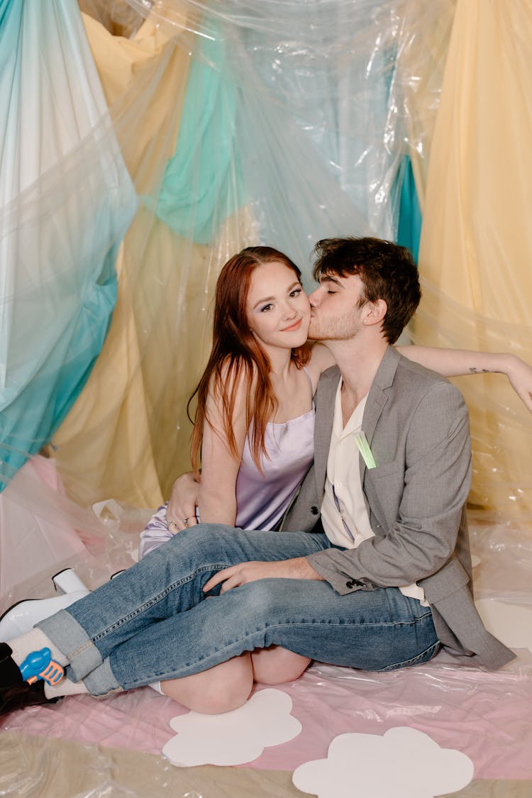 A Man Kissing A Woman On Her Cheek