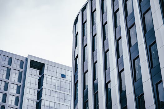 From below of exterior of contemporary residential buildings under cloudy sky in daylight