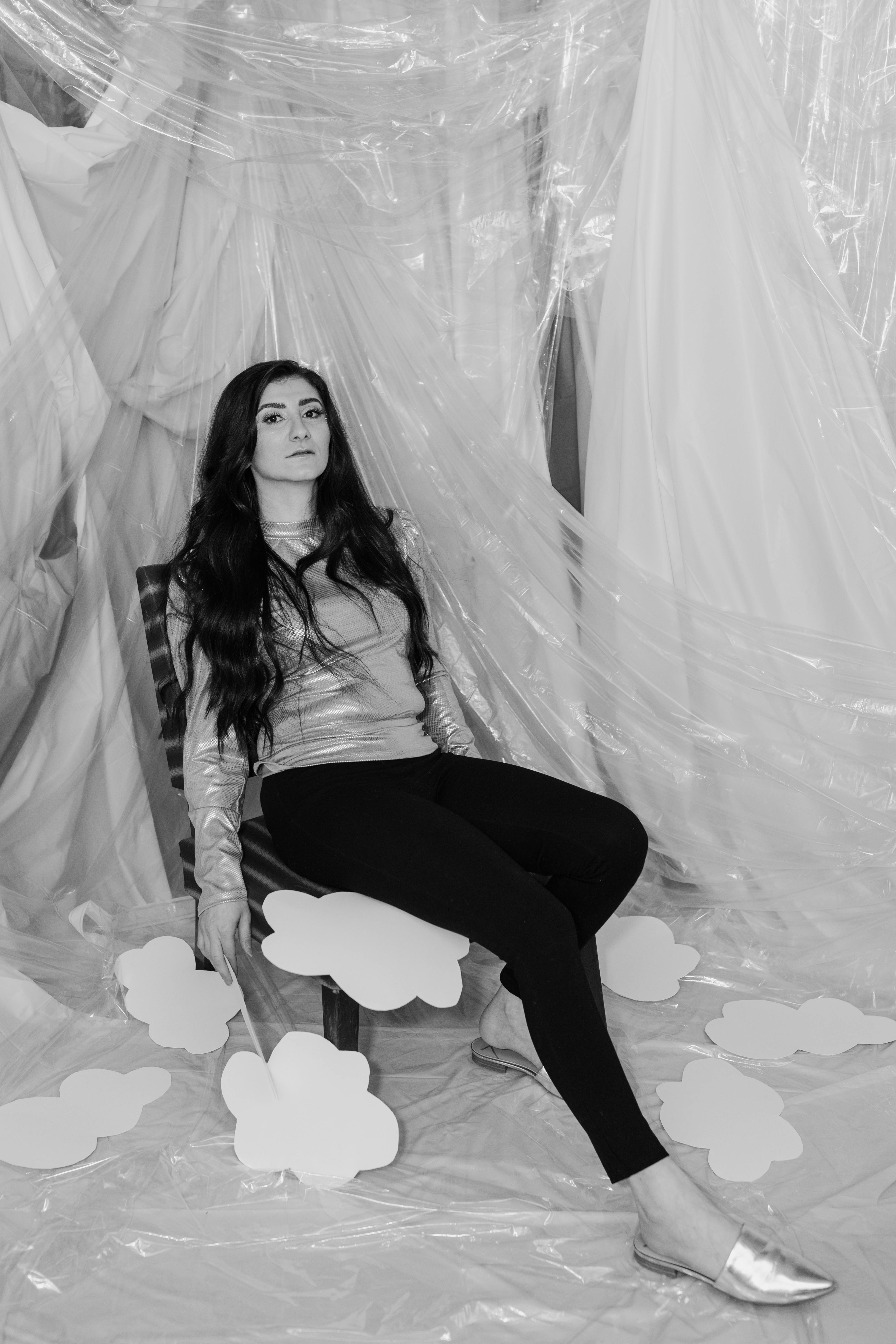 woman in black pants sitting on white textile