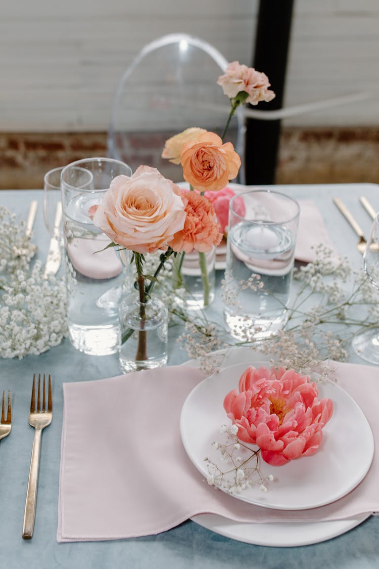 A Simple Table Setting With Fresh Rose Flowers On A Table