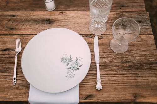 White Ceramic Plate and Clear Glasses on Wooden Table