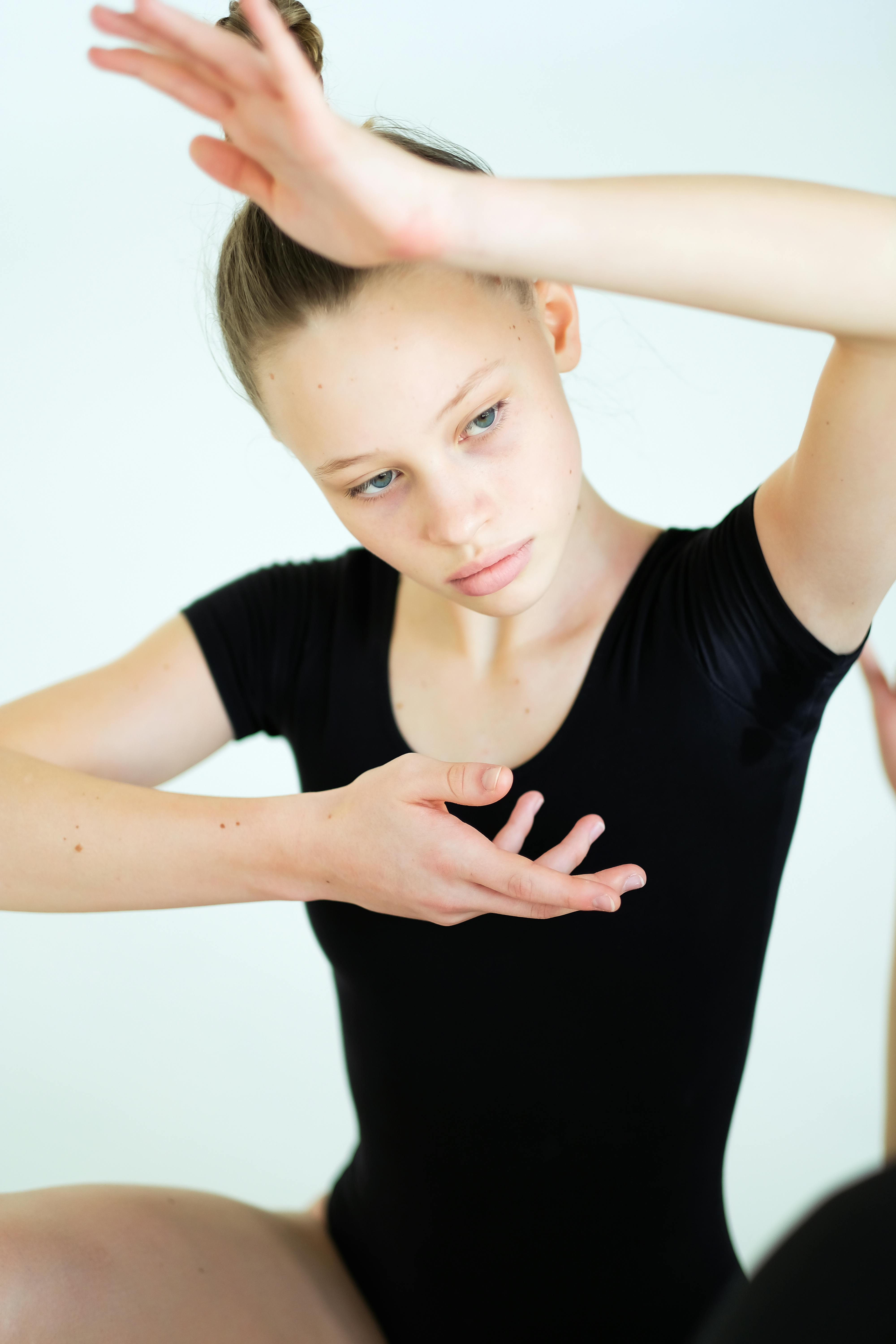 Portrait of a young ballerina in a thoughtful pose, showcasing elegance and grace.