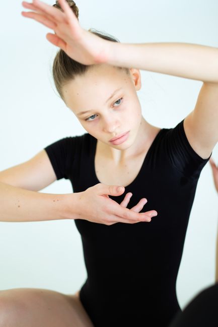 Portrait of a young ballerina in a thoughtful pose, showcasing elegance and grace.