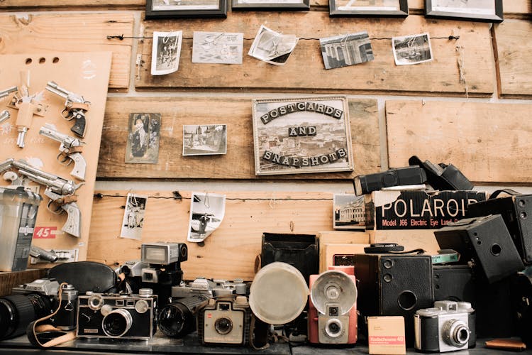 Antique Cameras And Firearms On A Wooden Shelf