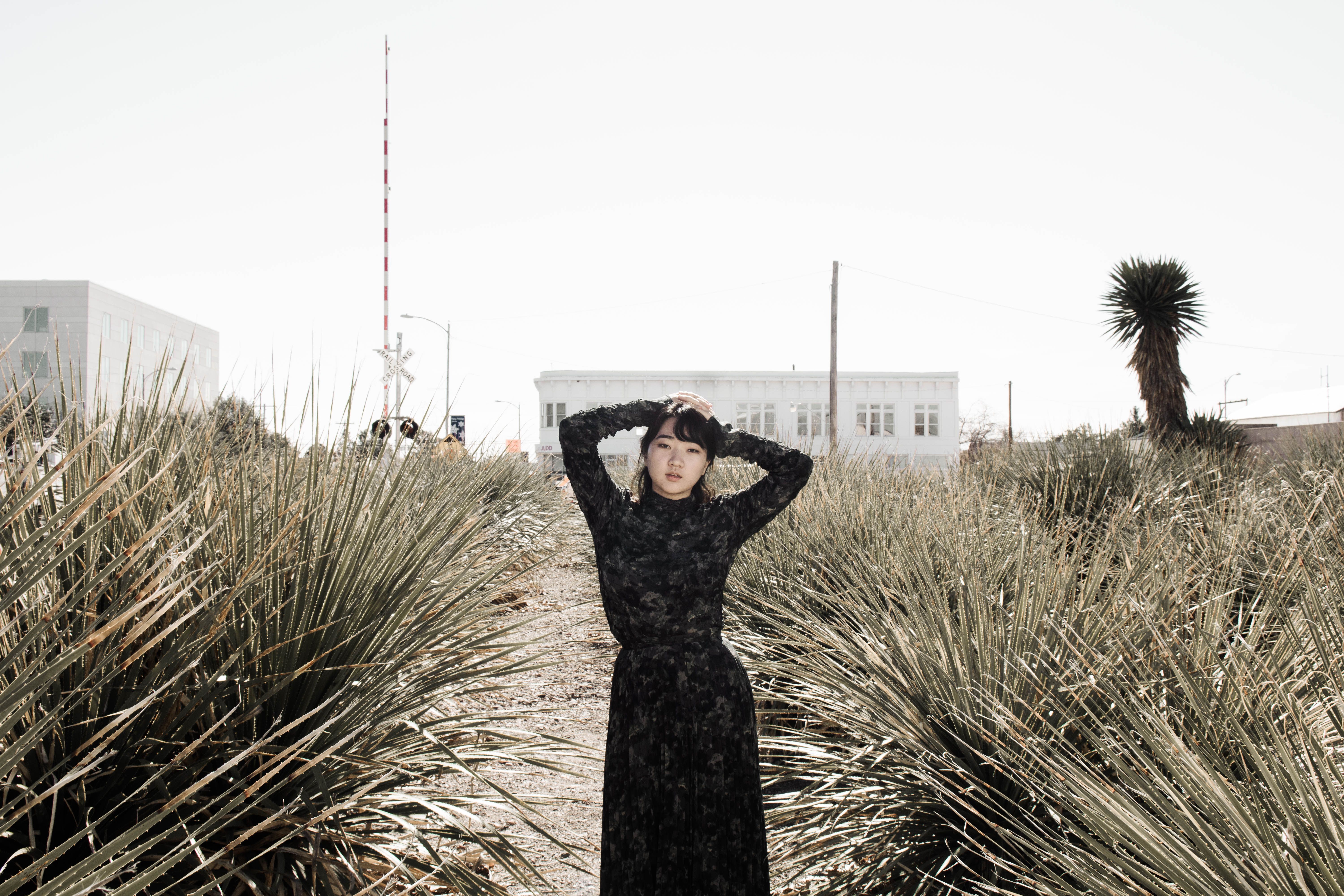 Woman in Black Long Sleeve Dress Standing on a Path · Free Stock Photo