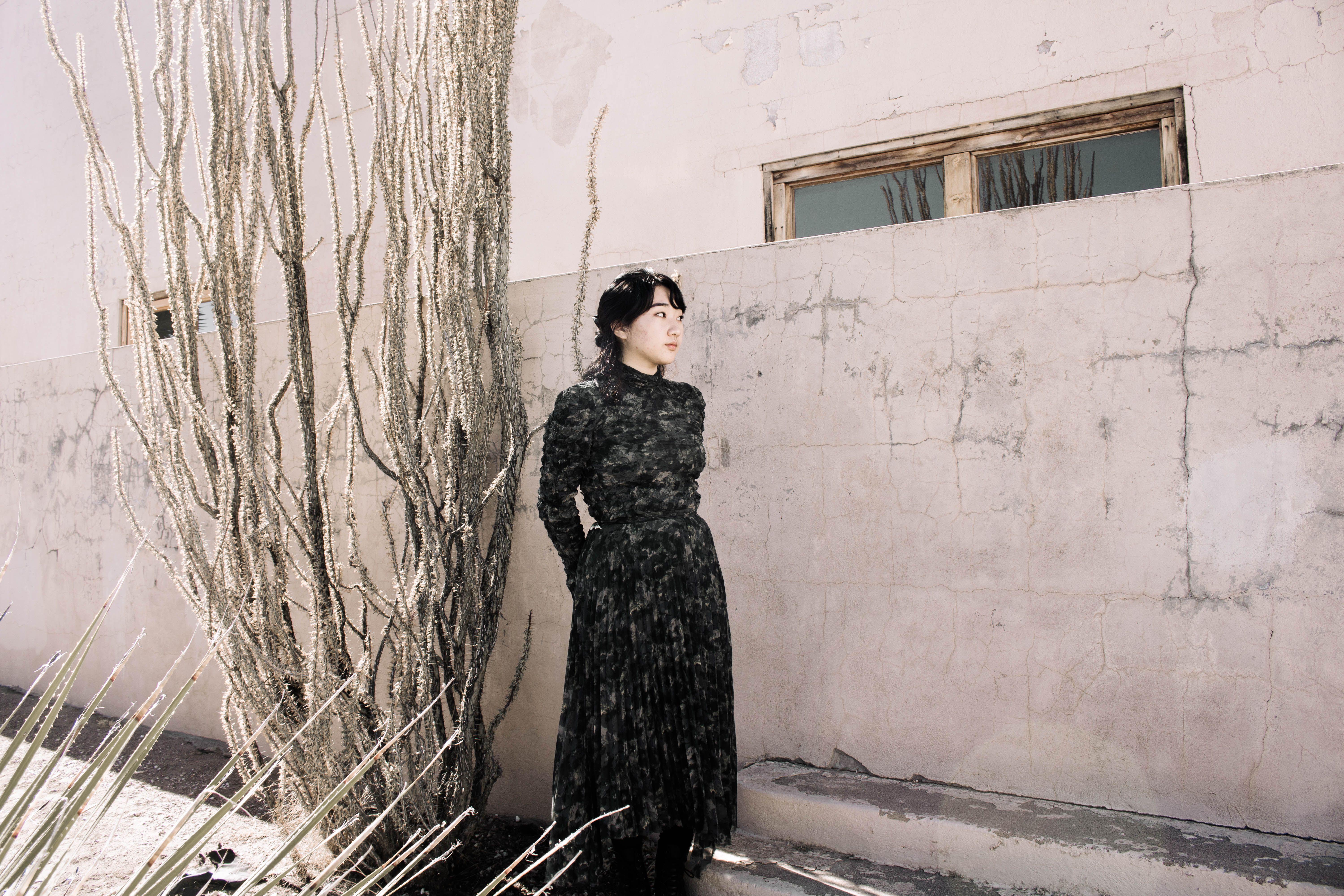Woman in Black Long Sleeve Dress Standing Beside a Wall · Free Stock Photo