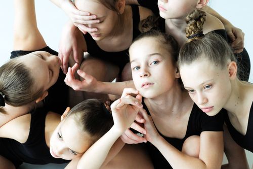 Free A group of young girls in black dresses poses gracefully, showcasing friendship and choreography skills. Stock Photo