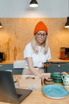 Woman packaging earthenware in a kitchen setting, organizing for shipping.