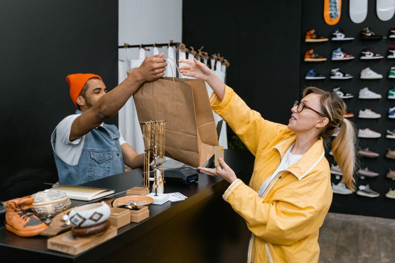 Shop owner handing a shopping bag to a customer