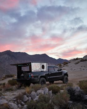 Pickup truck parked in desert landscape at sunset, highlighting adventure and nature.