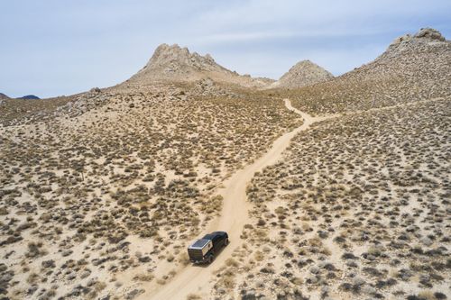 Free Explore the vast desert landscapes of Inyokern, CA with this stunning aerial view of a vehicle navigating a dirt road. Stock Photo