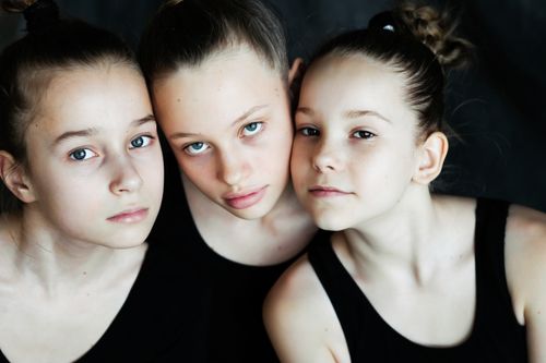 Free Close-up portrait of three girls in black tops, showcasing unity and friendship. Stock Photo