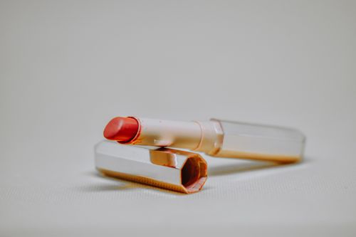 Free Close-up of a red lipstick with a sleek case on a neutral backdrop, perfect for beauty product photography. Stock Photo