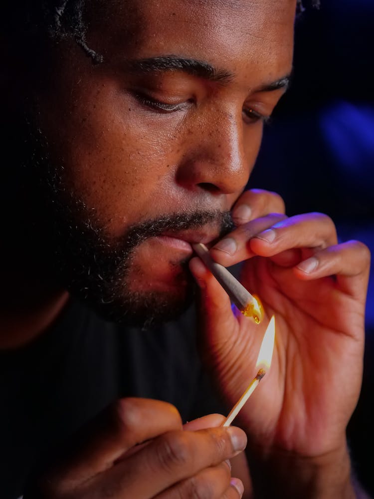 Close-Up Photo Of Man Lighting Up The Blunt